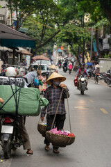 Naklejka premium Vietnamese woman selling fruit and vegetables on the street. Traditional sale. Hanoi