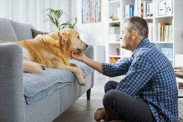 Pet owner cuddling his dog at home