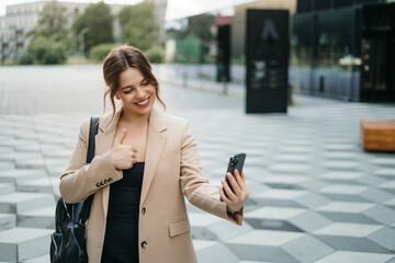 Fototapeta premium Happy woman using mobile app on smartphone to make video call, waving and greeting friends or family, talking on video call, staying connected at a distance