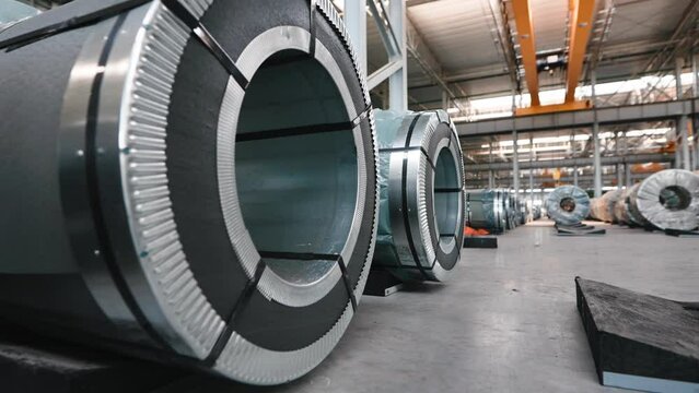 Industrial workshop and warehouse for storage and distribution of products of a metallurgical plant. Coiled steel is stored in rows in a modern warehouse.