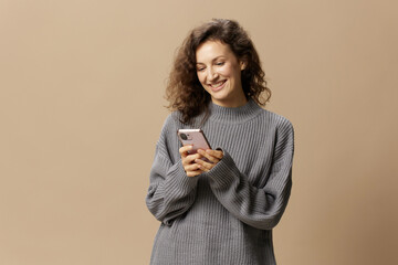 Lovely happy curly beautiful female in gray casual sweater chatting with boyfriend posing isolated...