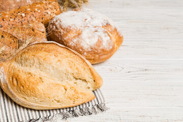 Homemade natural breads. Different kinds of fresh bread as background, perspective view with copy space