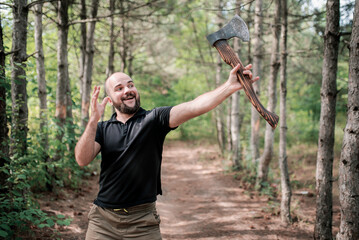 A bearded man holds an axe and raises it up. Winning stance