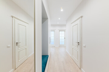 a large bright corridor with a mirror in the new design of the interior of the house