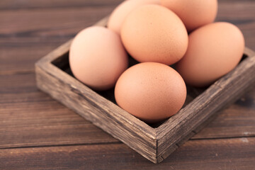 Wooden box with several eggs on the table
