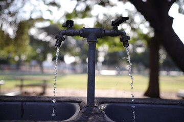 Two water taps and trickles of running water