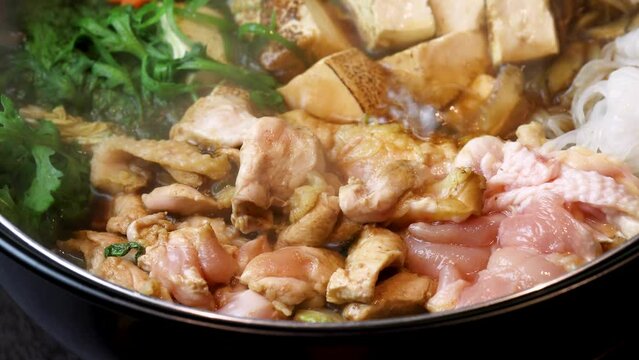 ぐつぐつと沸騰し、食欲をそそる湯気が立ち上る「地鶏のすき焼き」。弾力ある地鶏の質感と新鮮な野菜の色彩が際立つ動画素材は、冬の宴会メニューや、本格的な鍋料理を紹介する販促広告に最適な高品質素材です。 | Steaming hot Sukiyaki with premium local chicken and vegetables.