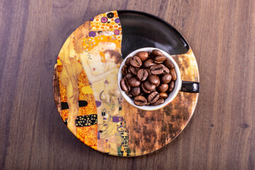 Aerial view of natural coffee beans in an artistic cup painted like a famous painting.International Coffee Day concept. October 1st.