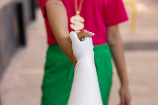 Woman holding hands of mannequin