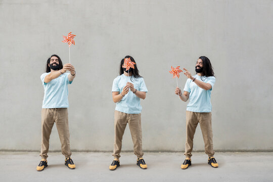 Multiple image of smiling bearded man with toy pinwheels in front of wall