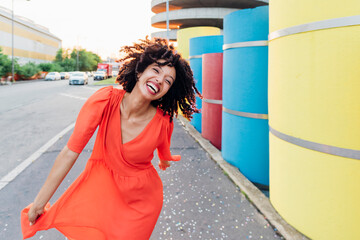 Happy woman enjoying dance by multi colored pipes