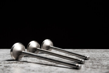 Car engine valves lie on the table on black background.