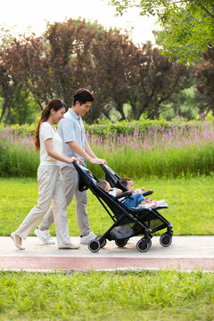 Young Chinese parents with twin babies in strollers