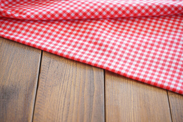 crumple pink plaid fabric or tablecloth on wood desk with selective focus