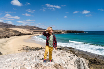 Naklejka premium Small boy enjoying at beach called Caleta del Congrio in Los Ajaches National Park at Lanzarote, Canary Islands, Spain