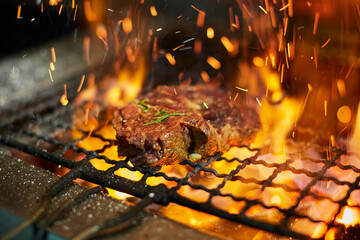 raw meat steak on grill grate with fire