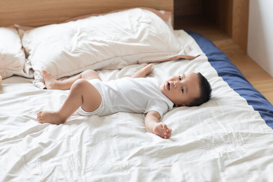 Cute Chinese baby lying on bed
