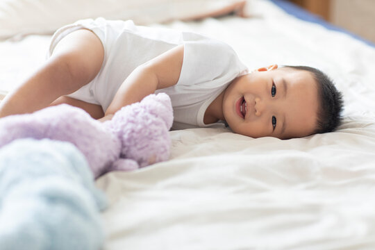 Cute Chinese baby lying on bed