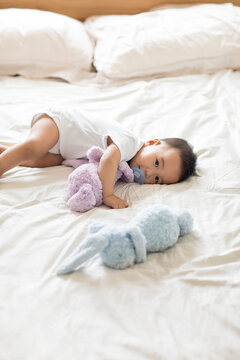 Cute Chinese baby lying on bed with pacifier
