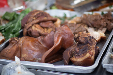 Braised pork knuckle in metal tray with vegetables