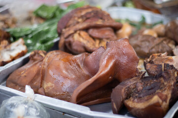 Braised pork knuckle in metal tray with vegetables