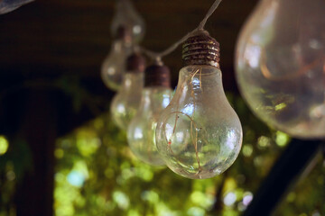 Garland of light bulbs in the gazebo. Selective soft selective focus. A place to spend, relax and work