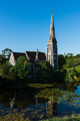 St Alban's Church (English Church) In Copenhagen, Denmark with reflection on the pond in the foreground.