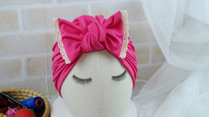 Turban hat with Arabic hat style on a mannequin head with hair accessories isolated headpiece. This turban fashion is very elegant, stylish, and modern. Indian hat with beautiful and casual design.