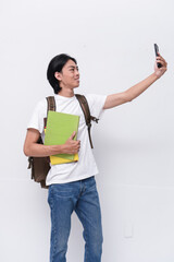young asian student with folder and mobile phone with backpack on white background