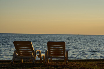 Fototapeta na wymiar Empty sun loungers with ocean view