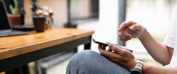 male hands using smartphone at cafe, searching or social networks concept, hipster man typing an sms message to his friends