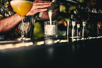 man hand bartender making cocktail in glass on the bar counter