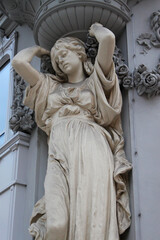 Beautiful woman figure statue, the facade of a historical building in the old town of Vienna, Austria, Central Europe. Detailed stone sculpture, exterior view of downtown houses.
