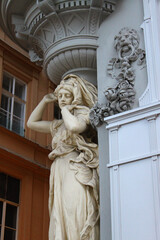 Beautiful woman figure statue, the facade of a historical building in the old town of Vienna, Austria, Central Europe. Detailed stone sculpture, exterior view of downtown houses.