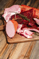 Tasty eco-friendly homemade smoked meats - sausage, ribs, bacon on wooden background