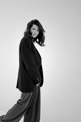 black and white portrait of young stylish woman wearing wide pants and jacket