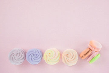 Set of desserts: macaroons, marshmallows and zephyrs, closeup. Traditional colored sweet desserts for the holiday. Flat lay. Copy space.