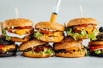 Fresh and juicy burgers on bright background, different burgers stacked on each other, fast food restaurant menu