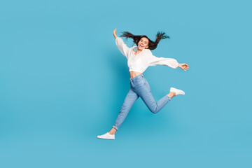 Fototapeta na wymiar Full body portrait of overjoyed satisfied lady jump flight isolated on blue color background