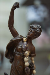 statue of a bronze-colored woman, sold at a fair in the city. Close-up of the statue.