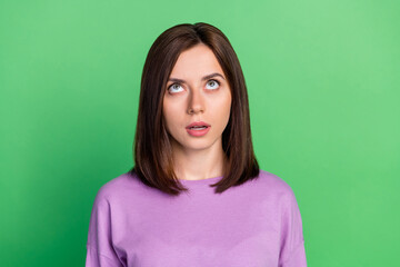 Obraz premium Closeup photo of young attractive woman looking up interested information speechless isolated on green color background