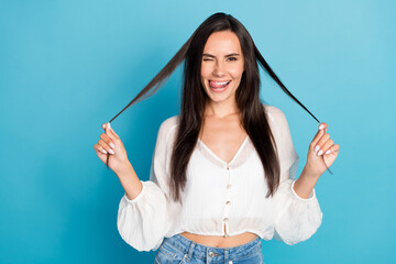 Photo of adorable funny young lady wear white top winking showing tongue arms hair curls empty...