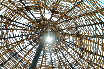 underside of a straw umbrella on the seaside coast, under shiny sun on the beach