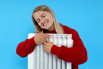 Heating season, woman with heater on blue background