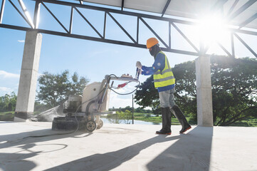 Construction workers use a machine to polish and finish surfaces or epoxy concrete on the home site.