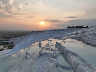 Pamukkale Travertines Cinematic Aerial Drone footage. Turkish famous white thermal bath with healthy clean water in a beautiful sunset. 