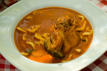 Traditional fish dish from Serbia food (serbian cuisine) and Hungarian cuisine- hot chili paprikaš soup with fresh catch of the day of Danube fish, red paprika and homemade pasta