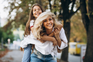 Fototapeta premium Mother with daughter together in autumn park