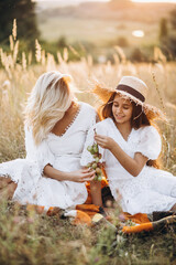 Mother with daughter having picnic together in a field