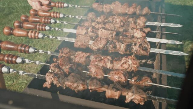Roasted meat on an open fire, shish kebab, meat close-up. Slow motion